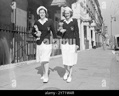 Les femmes olympiques britanniques sortent pour une promenade matinale. L'équipe olympique féminine britannique a été installée dans ses quartiers à Eccles ton Square, Westminster, hier. Ce matin, des membres ont été vus dehors pour une promenade vêtus de leurs uniformes olympiques. Images montrent:- Mme Dorothy Tyler (à droite) avec sa mascotte Lion Cub qui l'a accompagnée à Berlin pour les derniers Jeux Olympiques, photographiée avec Mme Burt sifflet vue en marche ce matin. 29 juillet 1948 Banque D'Images