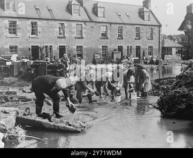 Grandes inondations dans le Nord. Des scènes de désolation ont été laissées dans le nord du Northumberland et le pays frontalier hier soir alors que les inondations qui avaient inondé des centaines de kilomètres carrés, balayant cinq voies ferrées et au moins quatre ponts routiers causant des glissements de terrain et isolant des villages, ont commencé à reculer. Photos : habitants de Cumledge, Berwickshire, qui se sont dégagés après la disparition des inondations. Notez la maison naufragée sur la droite et le niveau de la marque d'eau sur les maisons. 14 août 1948 Banque D'Images