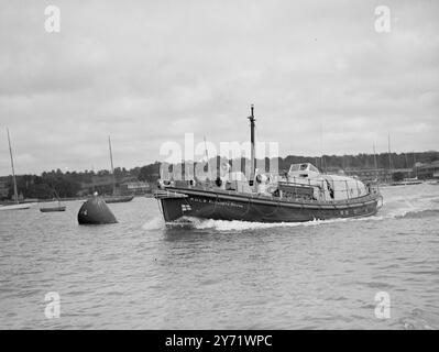 Nouveau Life Saver à l'essai. Un nouveau canot de sauvetage construit par la Royal National Lifeboat institution pour sa station à St Helier, Jersey, a fait un essai à Cowes avec l'inspecteur en chef adjoint des canots de sauvetage, le commandant T G Michelmore, au commandement. Il est le premier canot de sauvetage à être construit avec une cabine de pont, combiné avec d'autres nouvelles et intéressantes caractéristiques, qui comprennent un appareil de radiotéléphonie spécial, et pour la première fois dans les canots de sauvetage, des moyens de cuisson. La cabine du pont offre des sièges abrités pour 11 personnes de plus, avec de la place, si nécessaire, pour une civière. La photo montre : le St Helier Lifeboat Underg Banque D'Images
