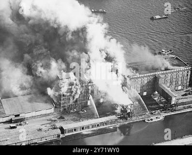 Les vivres brûlent dans l'incendie des docks d'Amsterdam. Un incendie s'est déclaré dans deux des entrepôts frigorifiques les plus grands et les plus modernes d'Amsterdam Docks, tôt le samedi matin. Le feu qui s'est propagé rapidement, s'est nourri des grands magasins de viande, de graisse, de beurre, d'oeufs et de poisson, qui étaient stockés dans les entrepôts pour l'approvisionnement hivernal de la population néerlandaise. L'ensemble des pompiers d'Amsterdam avec tous ses moteurs de conduite et flottants a été appelé sur les lieux de l'incendie. La quantité de nourriture et d'argent perdue dans l'incendie ne peut pas encore être estimée, mais elle s'élèvera certainement à des millions de florins. Photos : Banque D'Images
