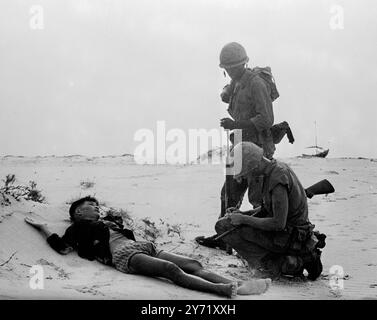 Nom, rang et numéro de série... CHU Lai, Sud-Vietnam : sur un arrêt de sable près de la base aérienne de Chu Lai, deux Marines américains cherchent des informations auprès d'un suspect Viet Cong blessé qui a été capturé, en juillet 25 1965, lorsque les cols de cuir et les troupes sud-vietnamiennes ont attaqué un village voisin à la recherche des guérilleros communistes. Les terroristes Viet Cong sont rarement pris en uniforme. 20 janvier 1967 Banque D'Images