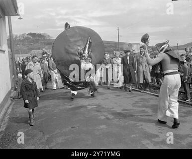 JOUR DE MAI DANS LE WEST COUNTRY : CHEVAL DE LOISIR À PADSTOW. - - Des scènes traditionnelles ont été vues hier à Padstow , Corwall , lorsque l'ancien ' OBBY OSS ' a été sorti et dansé dans les rues . Une bande de joueurs d'accordéon et de chanteurs a précédé le cheval , tandis que le ' Teaser ' portant un masque grotesque pour la première fois en 35 ans , danse devant le cheval. - - 2 mai 1948 Banque D'Images