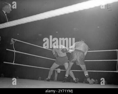 WOODCOCK B OMA COMBAT À HARRINGAY le champion de boxe poids lourds de la Grande-Bretagne, BRUCE WOODCOCK , est revenu sur le ring après une absence de 17 mois . Quand il a combattu LEE Oma de Chicago , dans un concours de huit tours à Harringay . Le dernier combat de Woodcock était dans ce même ring quand il a eu sa mâchoire fracturée et l'oeil endommagé dans son combat avec un autre américain JOE Baksi . IMAGES MONTRENT:- Woodcock ( face à la caméra) tire sur une gauche à Oma's Bosy , avec l'américain sur la défensive . 21 septembre 1948 Banque D'Images