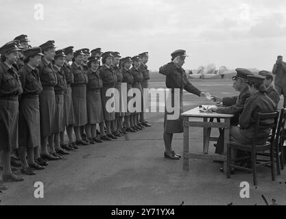 ' CONGÉS PAYÉS ' les femmes membres des unités de défense aérienne de la Royal Auxiliary Air Force et de la réserve de la W.A.A.F. qui sont au camp d'été annuel de la station R.A.F. , Coltishall , Norfolk , défilent pour leur solde . Les filles accomplissent un travail utile en lien avec la défense aérienne , et beaucoup d'entre elles font un travail similaire à ce qu'elles faisaient pendant les années de guerre. Des expressions souriantes sur les visages de la fille, ils semblent heureux à la perspective de vacances payées . 24 septembre 1948 Banque D'Images