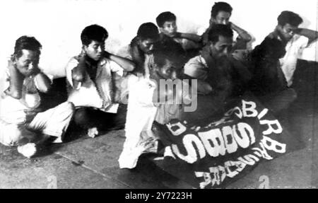 Communistes capturés : Djarkarta , Indonésie ; Un groupe de rebelles communistes capturés par l'armée au port de Tanjong Priok sont montrés accroupis les mains derrière la tête et la bannière 'SOBSI' déployée devant eux. 14 collèges universitaires et autres établissements d'enseignement supérieur en Indonésie ont été temporairement fermés en raison de la crise politico-militaire. Deux mouvements étudiants influencés par les communistes ont été suspendus pour avoir pris une part active à la récente tentative de coup d'État . 13 octobre 1965 Banque D'Images