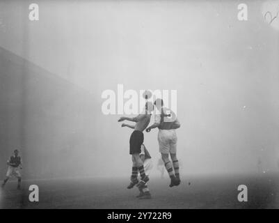 Association Football : Arsenal v Wolverhampton Wanderers. Les leaders de la Ligue Arsenal étaient à la maison des Wolverhampton Wanderers dans un match de Division I au Highbury Stadium cet après-midi (samedi). L'image montre : duel dans le brouillard. Leslie Compton (No5) et Smyth, l'intérieur gauche des Wolves, dans une bataille pour le ballon pendant le match tenu dans un épais brouillard à Highbury aujourd'hui. 6 mars 1948. Banque D'Images