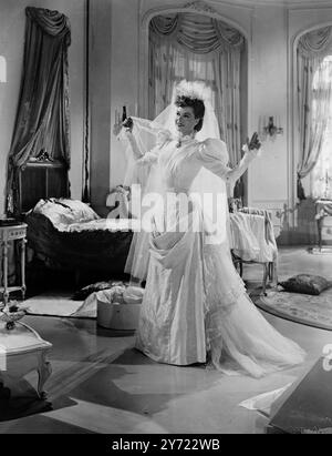 Edwardian bride. Belle peau claire Sally Gray, qui joue l'attrayante Sara bonheur dans le mélodrame des 2 villes 'Mark of Cain' est une mariée édouardienne, avec toute la délicatesse et le charme véhiculés par cette période gracieuse. Sa robe a un petit volants debout autour de la base de la gorge, attrapé par une broche en larme de perle antique. Jambe de manches de mouton équilibre la ligne drapée et busted de hanche qui coule dans un léger train de tulle. Les cheveux de Sally sont empilés dans le chignon et bang de la période et sa coiffe moussante en tulle et fleur d'oranger monte haut sur sa tête finissant dans un court raidissement Banque D'Images