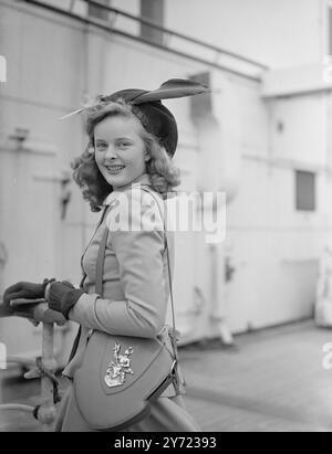 Doux nouveau look. Apportant un «nouveau look» de Jamaïque est Miss Virginia Tate de Londres, qui est arrivée à Southampton à bord du paquebot étoilé de Cunnard White «Queen Elizabeth» de New York aujourd'hui. Mlle Tate a été en voyage d'affaires avec son père qui est président de Tate et Lyle la célèbre entreprise sucrière. La photo montre : «Sweet dix-sept» Miss Virginia Tate porte un blason armorial sur la conception du bouclier de son sac en bandoulière, alors qu'elle arrive sur le «Q.. E' à Southampton aujourd'hui. 17 mars 1948. Banque D'Images