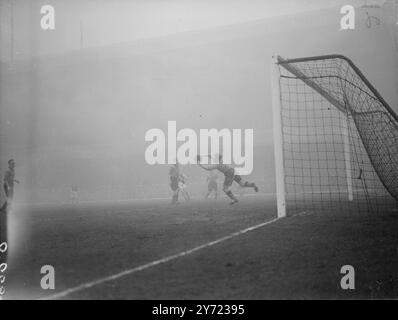 Association Football : Arsenal v Wolves. Les leaders de la Ligue Arsenal étaient à la maison des Wolverhampton Wanderers dans un match de Division I au Highbury Stadium cet après-midi (samedi). La photo montre : Williams, le gardien de but des Wolves saute pour tenir le ballon entre de bonnes mains après un tir de l'Arsenal à l'intérieur de la Forbes gauche (deuxième à partir de la gauche). 6 mars 1948. Banque D'Images