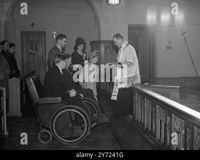 Mariage en fauteuil roulant. - - - - Des fauteuils roulants ont été utilisés par la garde d'honneur de son compagnon de patient lorsque l'ex-gardiens Coldstream, Sgt, George Swindlehurst, qui a été blessé en Allemagne, a épousé l'infirmière Winifred Doyle à l'église catholique St Edwards, Macclesfield, Cheshire. La mariée a fréquenté le Sgt Swindlehurst quand il était patient à l'hôpital militaire de Warrington. - - Spectacles : le père Coyne, dirige la cérémonie unissant le Sgt Swindlehurst et Miss Doyle à St Edwards. Bill Shiel (la caméra la plus proche) était le « meilleur homme » dans un fauteuil roulant comme le marié. - - - - 7 mars 1948. Banque D'Images