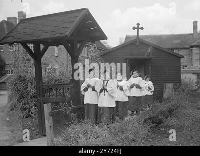 Spectacles de photos : garçons de chœur de la St Mary of the Angels Song Schoo, pratique pour un voyage de chant en Australie, à Addlestone, Surrey. Les garçons portent un « uniforme chantant » de blouse bleu ciel et leurs motorboards ont des pompons bleu ciel. 8 avril 1948. Banque D'Images