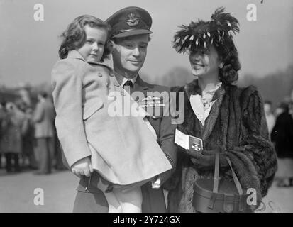 Investiture au Palais. Deux cent trente hommes et femmes, dont cinq chevaliers Bachelor, ont reçu des décorations de sa Majesté le Roi lors d'une investiture officielle qui s'est tenue ce matin (mercredi) dans la Grande salle du Palais de Buckingham. Images : Mme Pauline page était habillée pour le printemps quand elle accompagnait son mari, S/LDR. Geoffrey page, sera investi avec le D.S.O et le D.F.C lors de l'investiture de ce matin. La nièce de cinq ans du chef d'escadron, Ann bride, dresse le tableau. 24 mars 1948. Banque D'Images