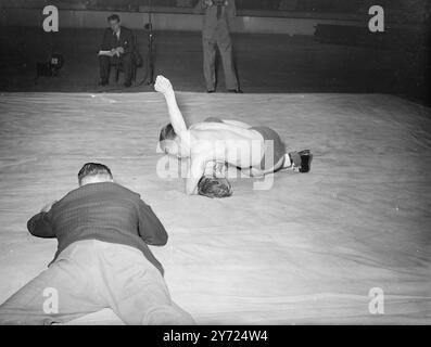 Des lutteurs de toute la Grande-Bretagne étaient en action à Harringay Arena, aujourd'hui (mardi) lorsque la British amateur Wrestling Association a organisé les championnats britanniques et les essais olympiques. Image affichée:vue de l'arbitre. Descendre à elle pour voir le fair-play dans le combat entre L.. Dimmock (Londres) - il est au top - et R. Myland, également de Londres. 13 avril 1948. Banque D'Images