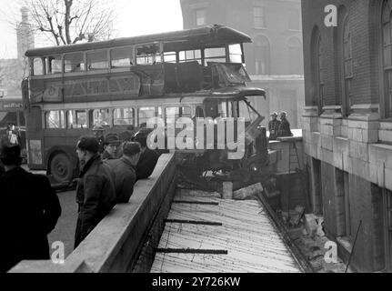 Passagers blessés dans une collision d'autobus et de tramway. Un certain nombre de passagers ont été transportés à l'hôpital après qu'un bus No.10 et un tramway ont été en collision à Borough Road, Londres peu avant 9 heures aujourd'hui ( mercredi ) . L'autobus montait sur le trottoir et surplombait une zone de bassin. Son chauffeur a été gravement coupé et un homme avec une jambe cassée a été secouru du haut de l'autobus naufragé. Photo montre, le bus naufragé suspendu au-dessus du sous-sol de Borough Road, Londres, après le smash ce matin (mercredi). 25 février 1947 Banque D'Images