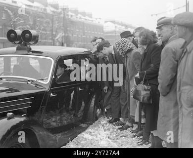 'As-tu vu Eileen ?' Police Tour rues avec photo. Squads of police haut-parleur cars Today, (dimanche) a visité les rues East End et City avec une photo agrandie d'Eileen Lockhart, la jeune fille de cinq ans qui a été retrouvée étranglée dans un sous-sol de Friendly House Finsbury, après qu'elle avait disparu de sa maison à Willington Way, Bow pendant trois jours. Ils arrêtèrent les passants à divers moments, leur montra la photo et leur donnèrent une description complète de la jeune fille assassinée. Images : les foules étudient l'image engloutie d'Eileen Lockhart, comme un policier donne sa description ove Banque D'Images