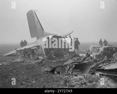 Dakota crash, 19 morts. Seuls 3 des 22 occupants de l'avion belge Sabine Dakota se sont échappés avec leurs vies et leurs avions, arrivant dans un épais brouillard à l'aéroport de Londres hier soir, ont heurté le tarmac qui a rebondi dans les airs, sont tombés à nouveau et ont explosé. Cette flamme et ce métal chaud blanc volant ont empêché le sauvetage de 16 passagers et de l'équipage de 3. À l'exception de la queue, la Time machine a été complètement brûlée. Images montrent : des fonctionnaires de la Direction des enquêtes sur les accidents du ministère de l'aviation civile examinant l'épave du Dakota à l'aéroport de Londres aujourd'hui (mercredi). 3e Banque D'Images