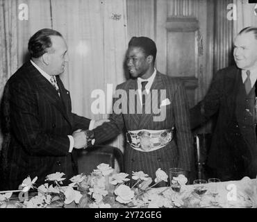 Lors d'une cérémonie de présentation tenue au restaurant Kettner, Cliff Anderson - champion poids plume de Guyane britannique, a reçu une ceinture d'argent de Mr. V. Brodsky (à gauche) souscrite par un sportif britannique « en signe d'estime pour son talent de boxeur et son courage et son esprit sportif à l'occasion de ce concours avec Al Phillips pour le titre poids plume de l'Empire britannique ». 30 juin 1947 Banque D'Images