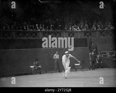 Les deuxièmes championnats de tennis sur gazon d'après-guerre ont ouvert devant une foule énorme au All England Club de Wimbledon aujourd'hui. Conformément à la tradition, le jeu s'est ouvert avec un match mettant en vedette le champion en titre. Yvon Petra, de France, vainqueur du simple masculin l'an dernier, a rencontré D.W.Butler, de Grande-Bretagne, sur le court central. Images : Yvon Petra, champion masculin en simple de 1946, en jeu contre D. W Butler sur le court central aujourd'hui. 23 juin 1947 Banque D'Images