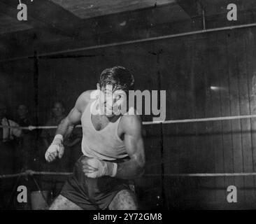 [Légende originale] Al Phillips, champion léger de Grande-Britienne, ne sourit pas sur le visage du « Tigre d'Aldgate », alors qu'il est pris dans cette photo flash ultra-rapide qui se déroule tout au long d'une période de boxe d'ombre lors d'un entraînement au Fratton Park, Portsmouth. Le 1er juillet à l'Olympia de Londres, il rencontrera la 'Black Panther' sous la forme de Cliff Anderson de Guyane britannique, quand ils se battront pour le champion de l'Empire britannique des poids légers. 25 juin 1947 Banque D'Images