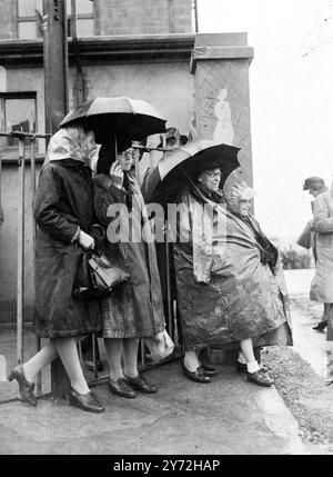 Malgré les fortes pluies tout au long de la matinée, des centaines de milliers de personnes se sont tournées vers Epsom Downs pour ce qui sera probablement le plus grand derby jamais vu. Les premiers coureurs s'efforcent de garder une partie de l'humidité pendant leur longue attente sur le parcours ce matin (samedi). 7 juin 1947 Banque D'Images