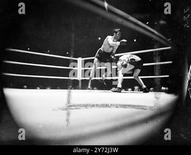 Al Phillips, champion poids plume de l'Empire, affronte Raymond Famechon lors d'un concours de 15 tours au Royal Albert Hall, pour le titre européen poids plume du Français. La photo montre : Philips (à gauche) se balance complètement du sol quand il ne parvient pas à connecter un coup à Raymond lors du combat de ce soir à l'Albert Hall. 27 mai 1947 Banque D'Images