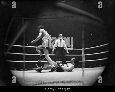 Al Phillips, champion poids plume de l'Empire, affronte Raymond Famechon lors d'un concours de 15 tours au Royal Albert Hall, pour le titre européen poids plume du Français. Famechon s'éloigne après avoir renversé Phillips pendant le combat de ce soir à l'Albert Hall. 27 mai 1947 Banque D'Images