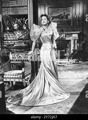 Vêtue de cette robe glamour de Cecil Beaton en satin violet de Parme, la star de cinéma hollywoodienne Paulette Goddard sera vue dans 'an Ideal Husband', ses premiers films britanniques, dans lesquels elle joue aux côtés de Michael Wilding. Le film qui est une adaptation à l'écran de la brillante pièce de théâtre d'Oscar Wilde, est une production cinématographique londonienne, produite et réalisée par Sir Alexander Korda. C'est la première photo de Miss Goddard de 'The Ideal Husband' à Shepperton. 21 mai 1947 Banque D'Images