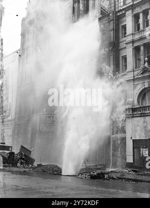 Une conduite d'eau a éclaté dans Oxford Street, cet après-midi, où la route était en cours de réparation. Normalement l'un des centres commerciaux les plus fréquentés de Londres, les bâtiments voisins ont été inondés d'eau lorsque le bec brisait les fenêtres de tous les étages, ayant atteint une hauteur considérable avant que la principale ne soit éteinte. 20 avril 1947 Banque D'Images