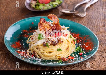 spaghetti carbonara avec salade sur bois Banque D'Images