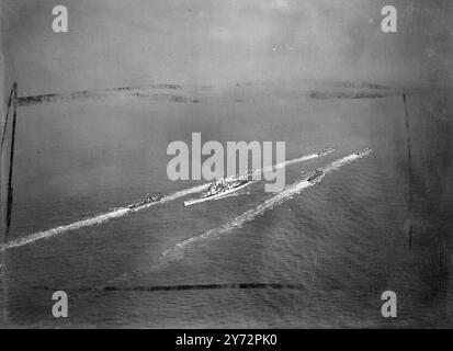 Le HMS Vanguard vole. Dans la lumière grise tôt le matin, avec une légère chute de neige, le plus puissant cuirassé britannique, le HMS Vanguard, a glissé lentement hors du port de Portsmouth aujourd'hui (samedi), transportant la famille royale en Afrique du Sud. Alors que le navire partait, le roi et la reine, avec les deux princesses, se tenaient sur la tourelle du canon pour reconnaître les acclamations d'adieu des spectateurs sur le quai. Photo montre, une vue aérienne du HMS Vanguard, avec l'équipage habité le long des rails et escorté par son escorte dans le canal 1 février 1947 Banque D'Images