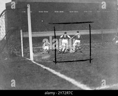 Arsenal contre Chelsea replay. Arsenal a rencontré Chelsea au Highbury Stadium, Londres, cet après-midi, mercredi, dans le replay suivant le match nul au pont de Stamford samedi. La photo montre , scrimmage autour de la bouche du but de l'Arsenal, à gauche numéro cinq, les Compton d'Arsenal, à droite numéro neuf, Tommy Lawton de Chelsea, et à droite (au sol), George Swindin, le gardien de but de l'Arsenal serrant la balle. 15 janvier 1947 Banque D'Images