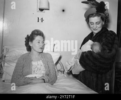 Son Altesse Royale la duchesse de Kent a visité l'hôpital St Georges de Londres, où elle a ouvert la nouvelle maternité. Images : son Altesse Royale la duchesse de Kent allaite Roger John Crook, un bébé de 12 jours, tandis que sa mère, Mme R. Crook, regarde de son lit dans la nouvelle maternité de l'hôpital. 12 décembre 1946 Banque D'Images