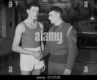 L’équipe de boxeurs amateurs suisses qui sont arrivés hier dans le pays et qui ont rencontré la Grande-Bretagne à l’Empire pool, Wembley, était occupée ce matin au gymnase Scotland Yard au poste de police de Cannon Row. Les boxeurs suisses ont été invités à utiliser le gymnase pour un réglage de dernière minute pour demain soir. Photos : les Heavyweigts opposés photographiés au Scotland Yard Gymnasium, le caporal du cheval Frank Walker et H. Jost (à droite) de Suisse. 10 décembre 1946 Banque D'Images