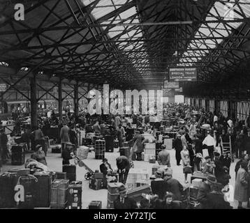 La reprise d'un service transatlantique normal de transport de passagers a ramené la prospérité à Southampton, qui a frappé la guerre. Les paquets de salaire des travailleurs sont gonflés dans le salaire des heures supplémentaires, les petites économies ont pris une tendance à la hausse, le chômage est à peu près le plus bas dans tout le pays. Au cours de cette semaine, 15 grands paquebots de passagers ou utilisent le port, et contribueront à hauteur de £20 000 en frais de port seulement. - - Spectacles de photos : la scène occupée dans le hangar des douanes bondé à Southampton montre certains passages de la «Reine Elizabeth» qui passent à travers. - - 19 novembre 1946 Banque D'Images