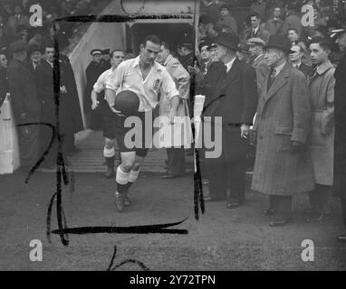 Près de 60 000 personnes ont vu l'Angleterre battre le pays de Galles par trois buts à zéro dans le premier international de football à être joué en Angleterre pendant huit ans au Manchester, Maine Road Stadium. Photo montre : le capitaine de l'Angleterre Hardwick entrant sur le terrain avec son équipe. 13 novembre 1946 Banque D'Images