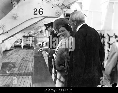 Avec la reine et les deux princesses à bord, le 85 000 t Cunnard - White Star Liner 'Queen Elizabeth' subit ses essais de vitesse officiels de la côte nord-est d'Arran, en Écosse. La photo montre sa Majesté la Reine, avec Sir Percy Bates, président du Liner, examine les initiales des militaires sculptés sur le rail du navire pendant son service de transport de guerre. Photo prise lors des essais de vitesse de la Reine Elizabeth lors de ses essais de vitesse et du Firth of Clyde. 8 octobre 1946 Banque D'Images