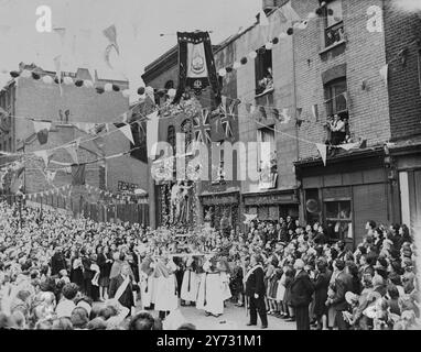 Mile long procession en l'honneur de notre-Dame du Mont Carmel. - - La 'petite Italie' de Londres a tenu sa procession religieuse annuelle aujourd'hui, dimanche, lorsque le cortège long d'un kilomètre partant de l'église italienne St Pierre (Saffron Hill) s'est déroulé le long de Clerkenwell Road, Farringdon Road et hatton Garden et les rues voisines. Dans la procession se trouvaient des statues de Sainte Lucie, Saint Antoine et la Vierge. Trois groupes ont fourni de la musique pour les hymnes anglais et italiens, des jeunes filles vêtues de bleu avec des voiles blancs et des représentants des pays européens dans leur costume national ont formé une partie pittoresque de la Banque D'Images