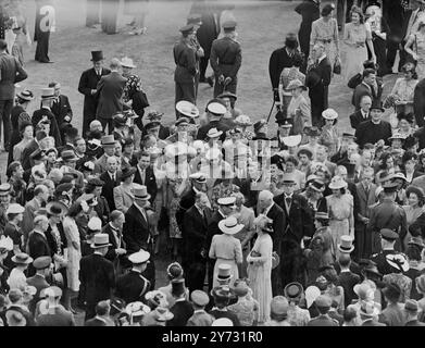 Une fête royale dans le jardin. Leurs majestés le Roi et la Reine cet après-midi (mardi) . 7000 invités ont été accueillis lors de la première fête royale d'après-guerre au palais de Buckingham. Des chapeaux et des manteaux de matinée ont été vus au Palais pour la première fois depuis avant la guerre, mais, avec le consentement du roi, de nombreux invités portaient une robe de service ou des costumes de salon. Spectacles de photos, sa Majesté le Roi se mêlant aux invités à la fête du jardin du palais de Buckingham cet après-midi. (Mardi). 9 juillet 1946 Banque D'Images