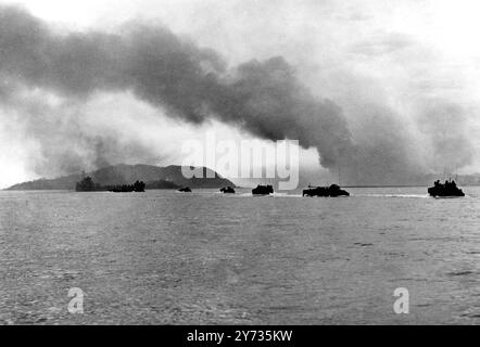 La ligne de petits navires transportant des troupes se déplace rapidement vers l'île Wolmi à Inchon ( Corée du Sud ) alors que la 1re division des Marines Amreican établit la base d'une campagne des Nations Unies vers Séoul tenue par l'ennemi. Les troupes se déplacent de Wolmi à la ville d'Inchon par une chaussée. Grand navire en arrière-plan à gauche est un lanceur de rockee-t engagé dans l'attaque de batteries côtières le 15 septembre 1950 Banque D'Images