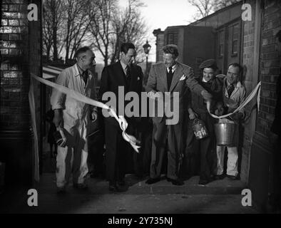 La star de l'écran Danny Kaye est passée aux studios Teddington pour effectuer la cérémonie de réouverture . Les studios ont été reconstruits après le bombardement de juillet 1944 à la suite des efforts de Jack l Warner de Warner Bros Pictures Ltd. Images : Danny Kaye coupe la bande pour rouvrir les studios Teddington reconstruits , sous le regard admiratif des ouvriers du studio . 29 janvier 1948 Banque D'Images