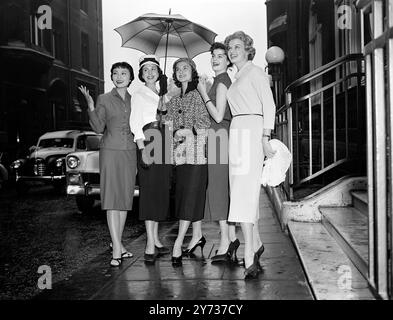 Cinq beautés sous un même parapluie sont en compétition dans le prochain concours Miss monde .... Quittant leur hôtel sous la pluie pour jeter un coup d’œil à Londres. De gauche à droite : Midoriki Tokura du Japon , Margaret Scherz de l'Autriche , Norma Vorster de l'Afrique du Sud , Sirpa Helena Koivu de la Finlande et Eva Brann de la Suède le 8 octobre 1956 Banque D'Images