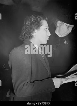 MME . PREMIER DISCOURS du MOPP Whitehall Cleaner , Mme . A.E. COSTA , a fait le premier discours public de sa vie ce soir quand elle a pris la parole lors de la Journée internationale de la femme à Friend's House , Euston Road , Londres sur '' salaire et conditions dans les fonctionnaires du gouvernement '' Mme Costa , porte-parole d'environ 250 nettoyeurs à l'Amirauté , nettoie les sols des bureaux du gouvernement depuis la mort de son mari en 1942 . Elle commence souvent à travailler à 6 heures du matin et fait parfois encore le ménage à la maison jusqu'à minuit. Ses gains sont de 1s.8d de l'heure. PHOTOS :- Madame OLGA Tournade , de France ( secr Banque D'Images