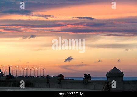 749 ciels brûlants au coucher du soleil illuminent le crépuscule sur le parapet de la digue du parc Parque Maceo de l'esplanade Malecon. La Havane-Cuba. Banque D'Images
