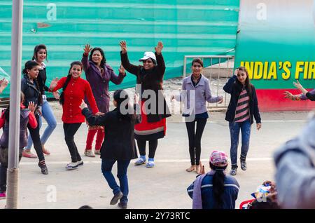 Touristes dansant pendant la cérémonie d'abaissement du drapeau à la frontière Attari–Wagah, au Pendjab Banque D'Images