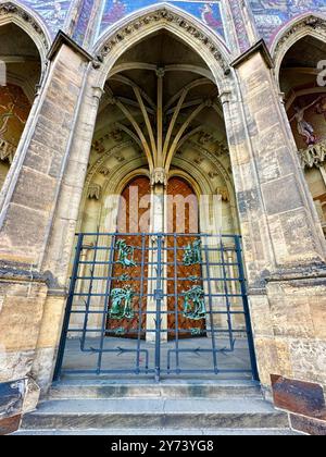 La photographie capture une vue détaillée d'une ancienne porte médiévale en bois et en métal, située dans les rues d'une ville européenne historique. Banque D'Images