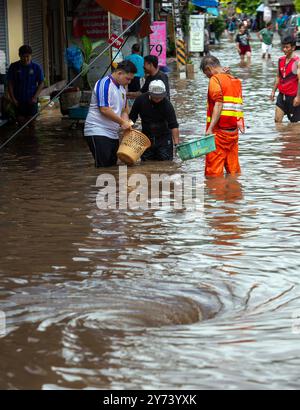 Chiang mai, Thaïlande. 27 septembre 2024. Des résidents et un travailleur du ministère de la Voirie aident à enlever les débris d'un drain après des crues soudaines causées par des précipitations continues. Les inondations à Chiang mai ont été causées par des précipitations continues, magasin d'électronique, ce qui a entraîné le ruissellement de Doi Suthep se jetant dans les zones de basse altitude. Les fortes pluies ont également provoqué le débordement de la rivière Ping à plusieurs endroits de la ville, endommageant des maisons et provoquant des embouteillages sur de nombreuses routes. (Photo de Pongmanat Tasiri/SOPA images/Sipa USA) crédit : Sipa USA/Alamy Live News Banque D'Images