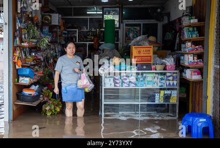 Chiang mai, Thaïlande. 27 septembre 2024. Une femme se tient à l'intérieur d'un magasin d'électronique inondé par des crues soudaines après des pluies continues. Les inondations à Chiang mai ont été causées par des précipitations continues, magasin d'électronique, ce qui a entraîné le ruissellement de Doi Suthep se jetant dans les zones de basse altitude. Les fortes pluies ont également provoqué le débordement de la rivière Ping à plusieurs endroits de la ville, endommageant des maisons et provoquant des embouteillages sur de nombreuses routes. (Photo de Pongmanat Tasiri/SOPA images/Sipa USA) crédit : Sipa USA/Alamy Live News Banque D'Images