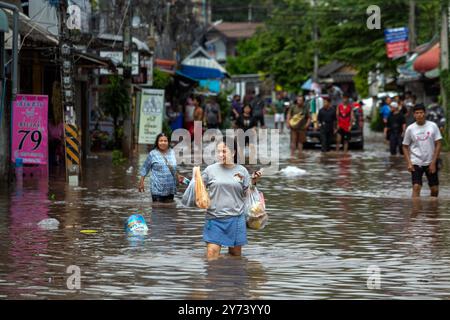 Chiang mai, Thaïlande. 27 septembre 2024. Une femme se tient debout dans une rue inondée après des crues soudaines qui ont inondé la zone à la suite de pluies continues. Les inondations à Chiang mai ont été causées par des précipitations continues, magasin d'électronique, ce qui a entraîné le ruissellement de Doi Suthep se jetant dans les zones de basse altitude. Les fortes pluies ont également provoqué le débordement de la rivière Ping à plusieurs endroits de la ville, endommageant des maisons et provoquant des embouteillages sur de nombreuses routes. (Photo de Pongmanat Tasiri/SOPA images/Sipa USA) crédit : Sipa USA/Alamy Live News Banque D'Images