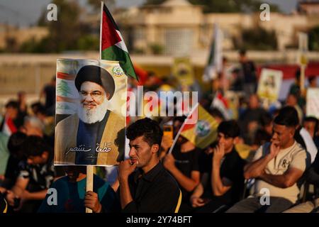 Mossoul, Irak. 27 septembre 2024. Partisan de la faction armée Kataeb Sayyid al-Shuhada (membre des forces hachées al-Shaabi/de mobilisation populaire ou PMF) tient un portrait du chef du Hezbollah Hassan Nasrallah lors d'une manifestation de solidarité contre l'agression israélienne contre le Liban et la Palestine près de la Grande Mosquée (non visible) de Mossoul dans la ville de Mossoul. Crédit : SOPA images Limited/Alamy Live News Banque D'Images