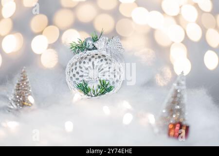 Concept de déoration de Noël en vacances avec un ange en porcelaine, fausse neige blanche pour un décembre festif. En arrière-plan sont des boules de bokeh faites de ligh Banque D'Images